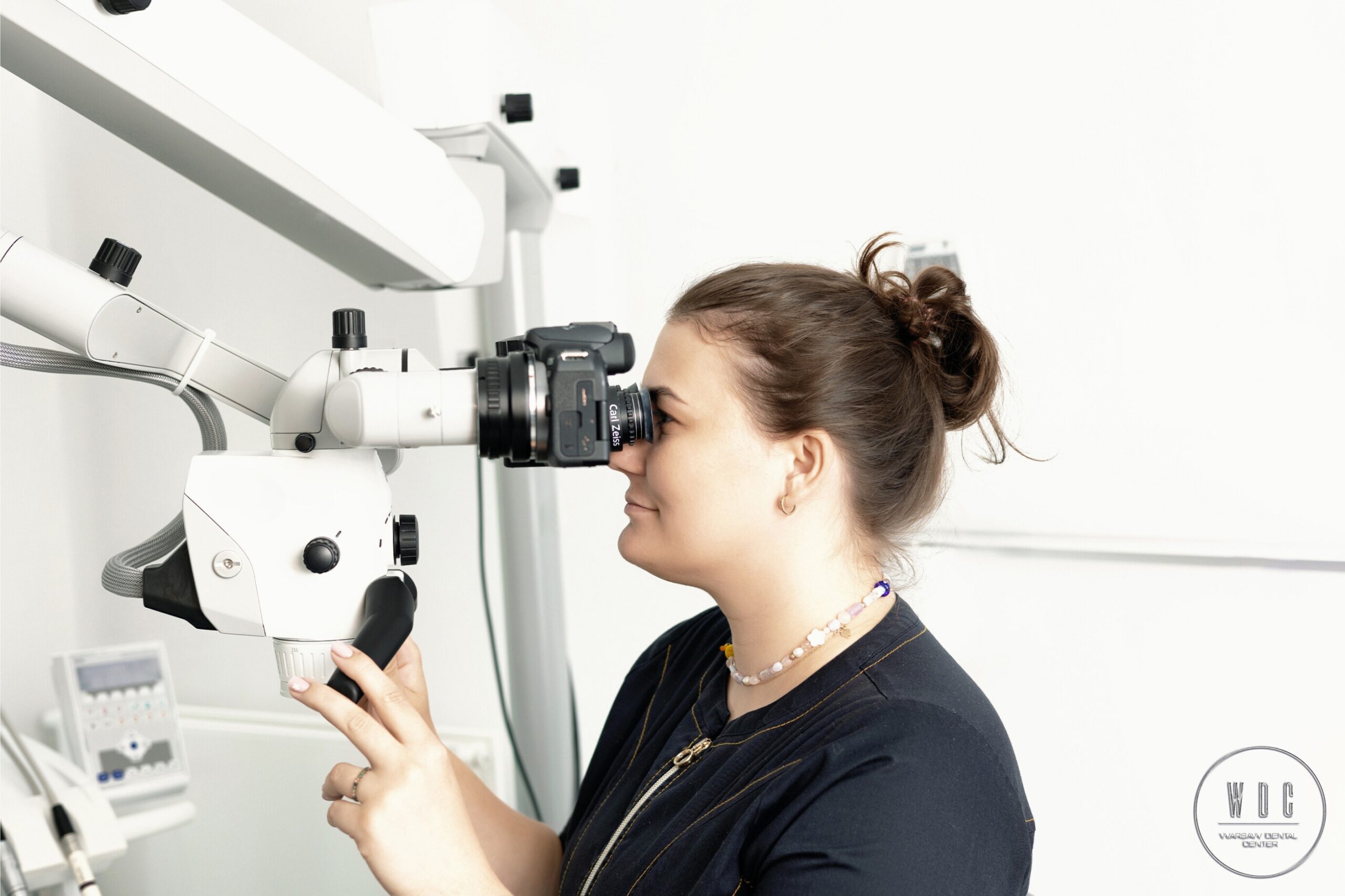 Lek. Dent Olga Rybińska z mikroskopem, ktorego używa do wszystkich zabiegów