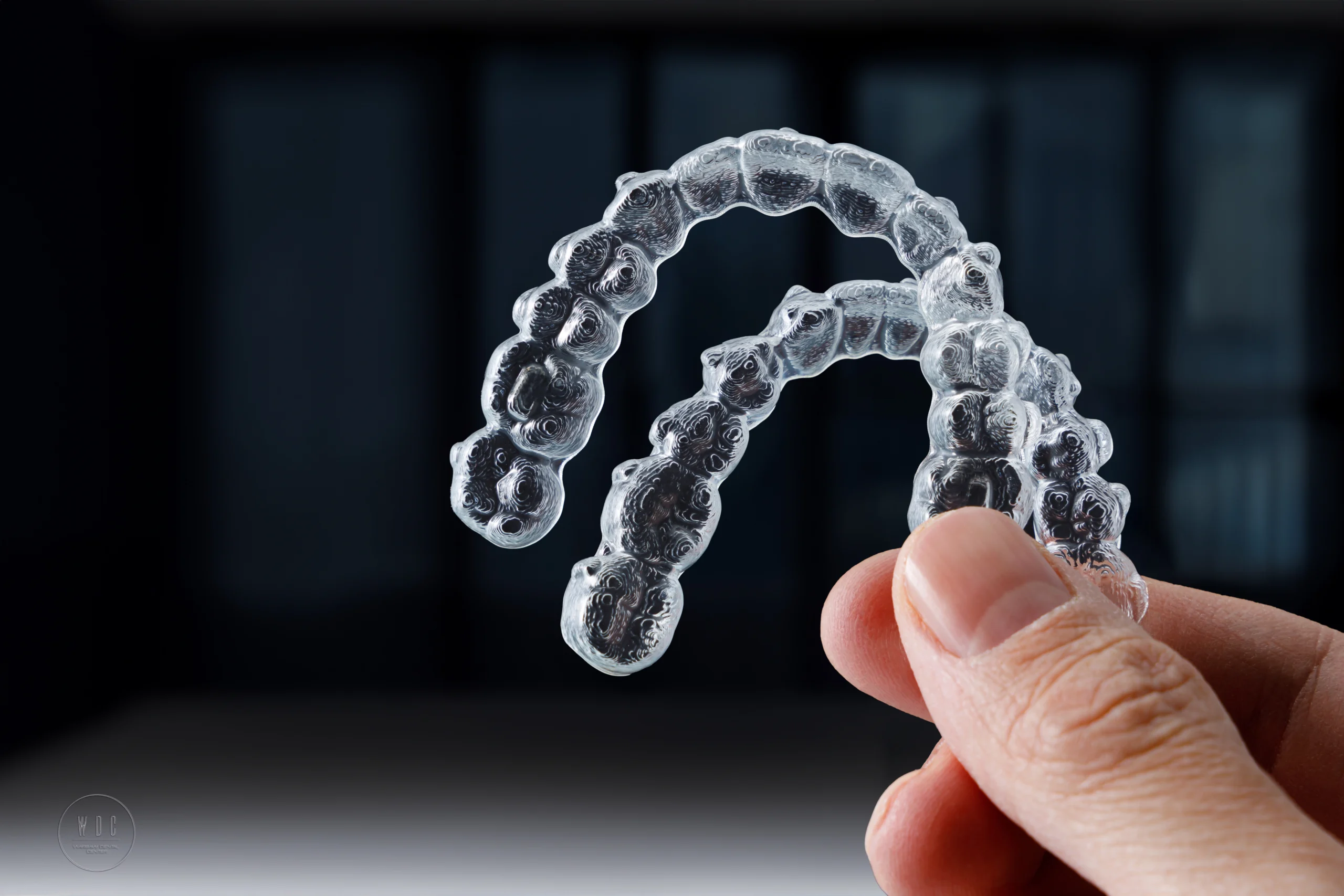 Dłoń trzymająca nakładki Invisalign