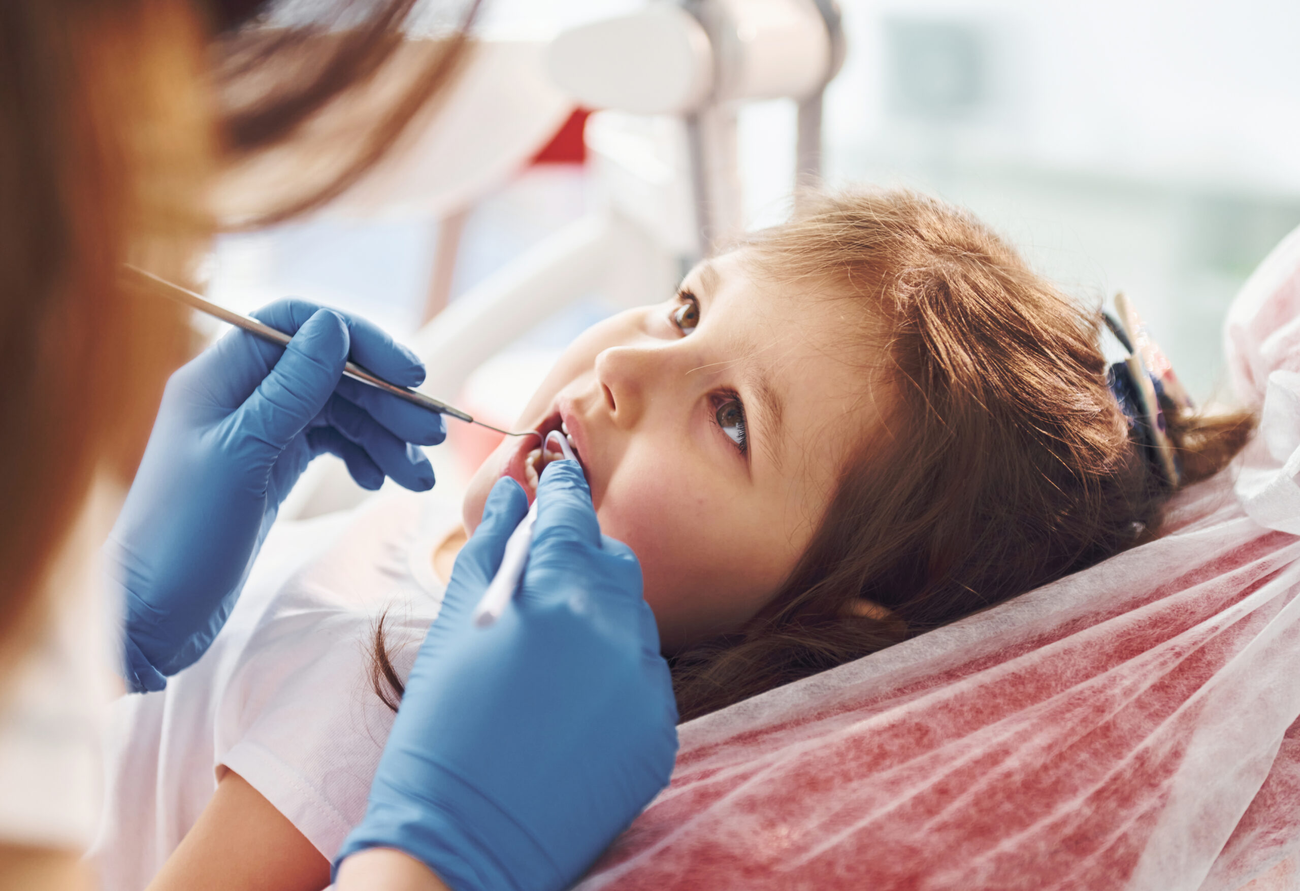 Little girl visiting dentist in clinic. Conception of stomatology.