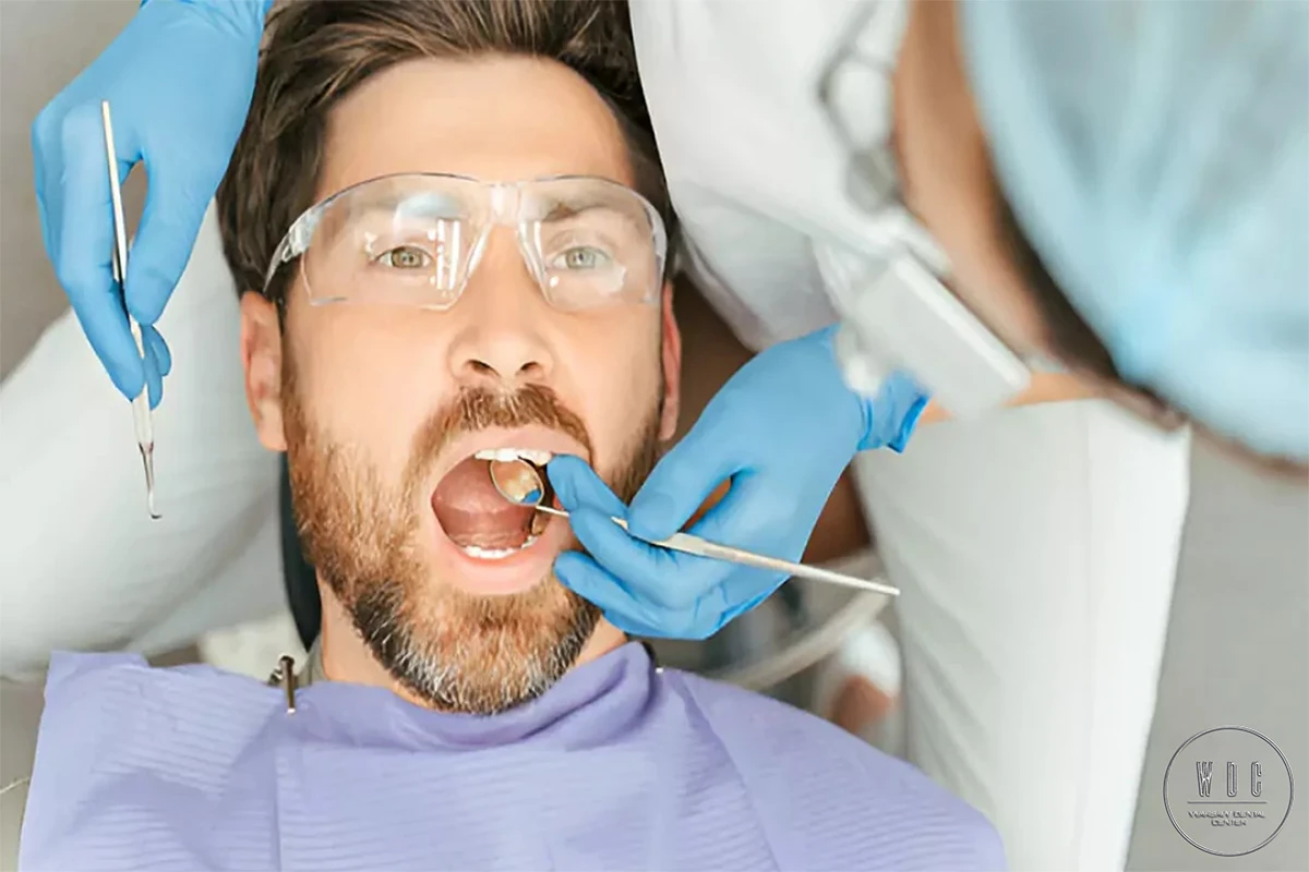 Man in the dental chair is receiving a filling.