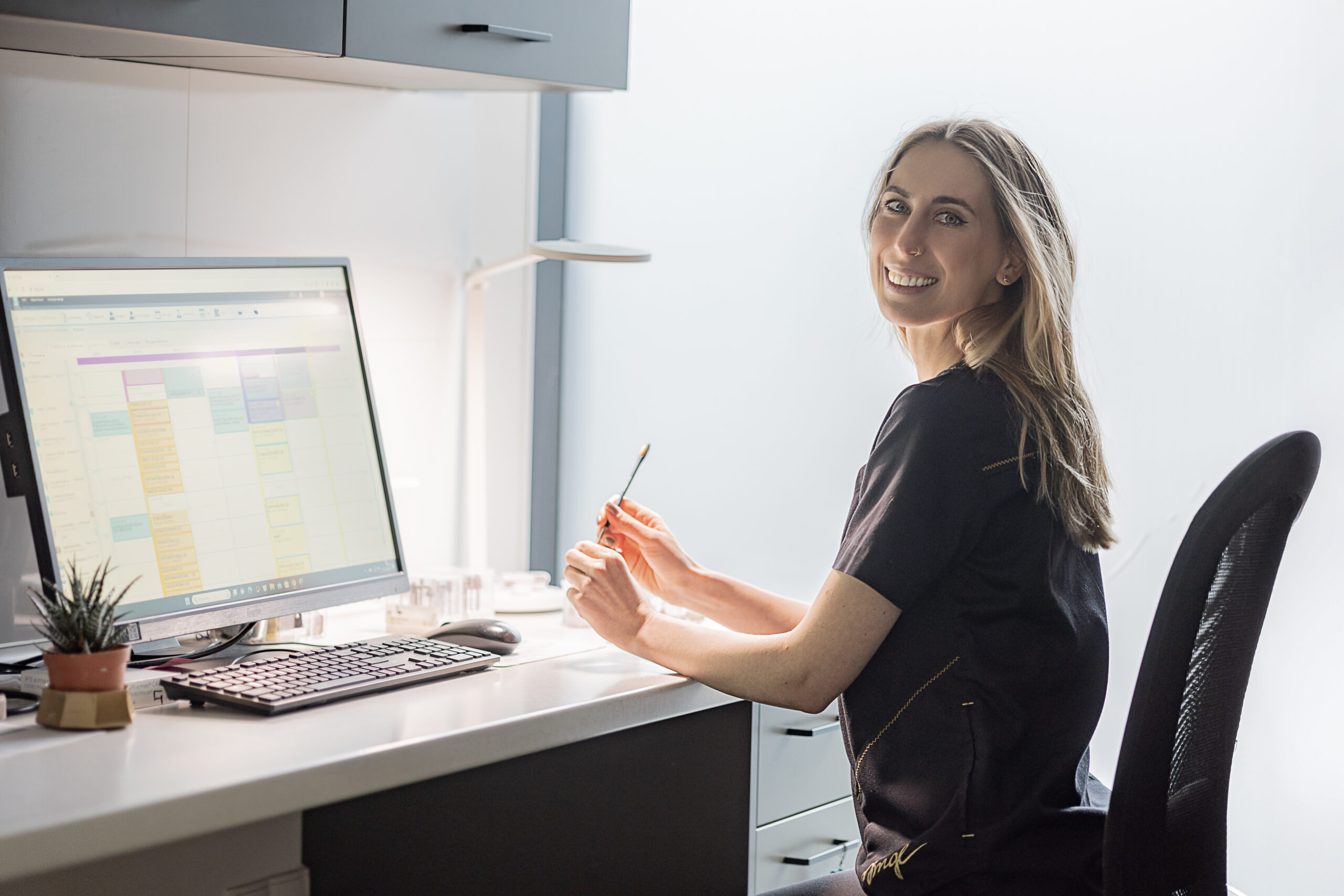 Dental technician Karolina Krause at the computer in a modern treatment room