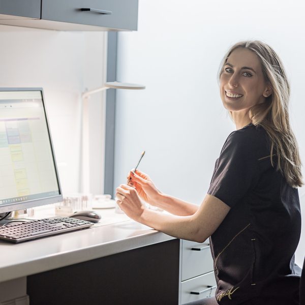 Dental technician Karolina Krause at the computer in a modern treatment room