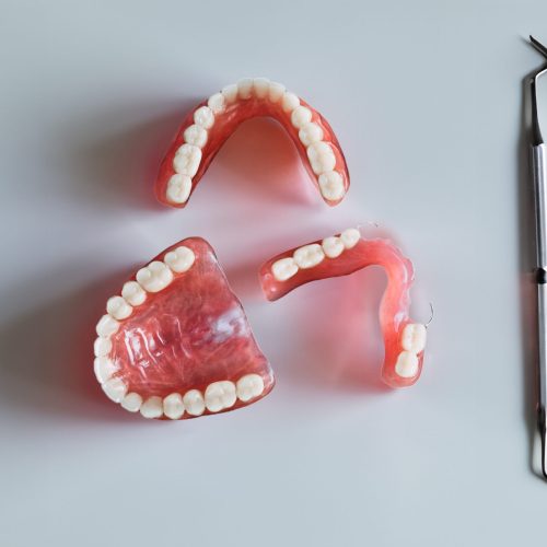 Dentures on a dark background. Close-up of dentures. Dentistry is conceptual photography. Prosthetic dentistry. False teeth. Prosthetics. Close-up of plastic dentures. Teeth on a wooden background