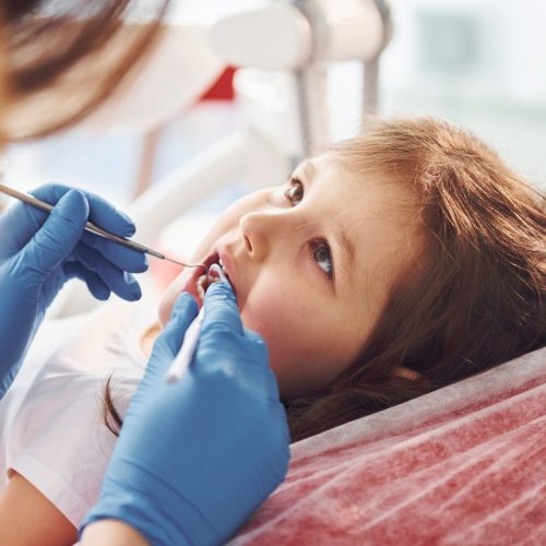 Little girl visiting dentist in clinic. Conception of stomatology.