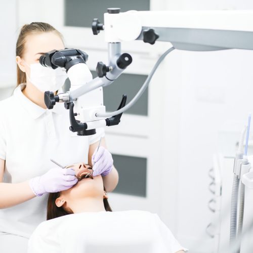 professional dentist examination patient with microscope at the office.